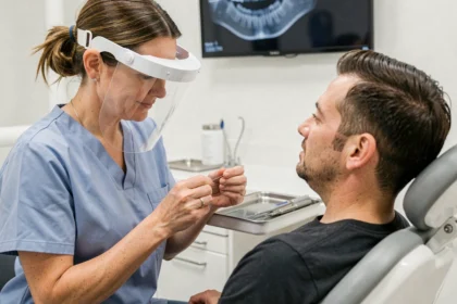 Dentiste femme expliquant les techniques de soins bucco-dentaires à un patient dans un cabinet dentaire moderne