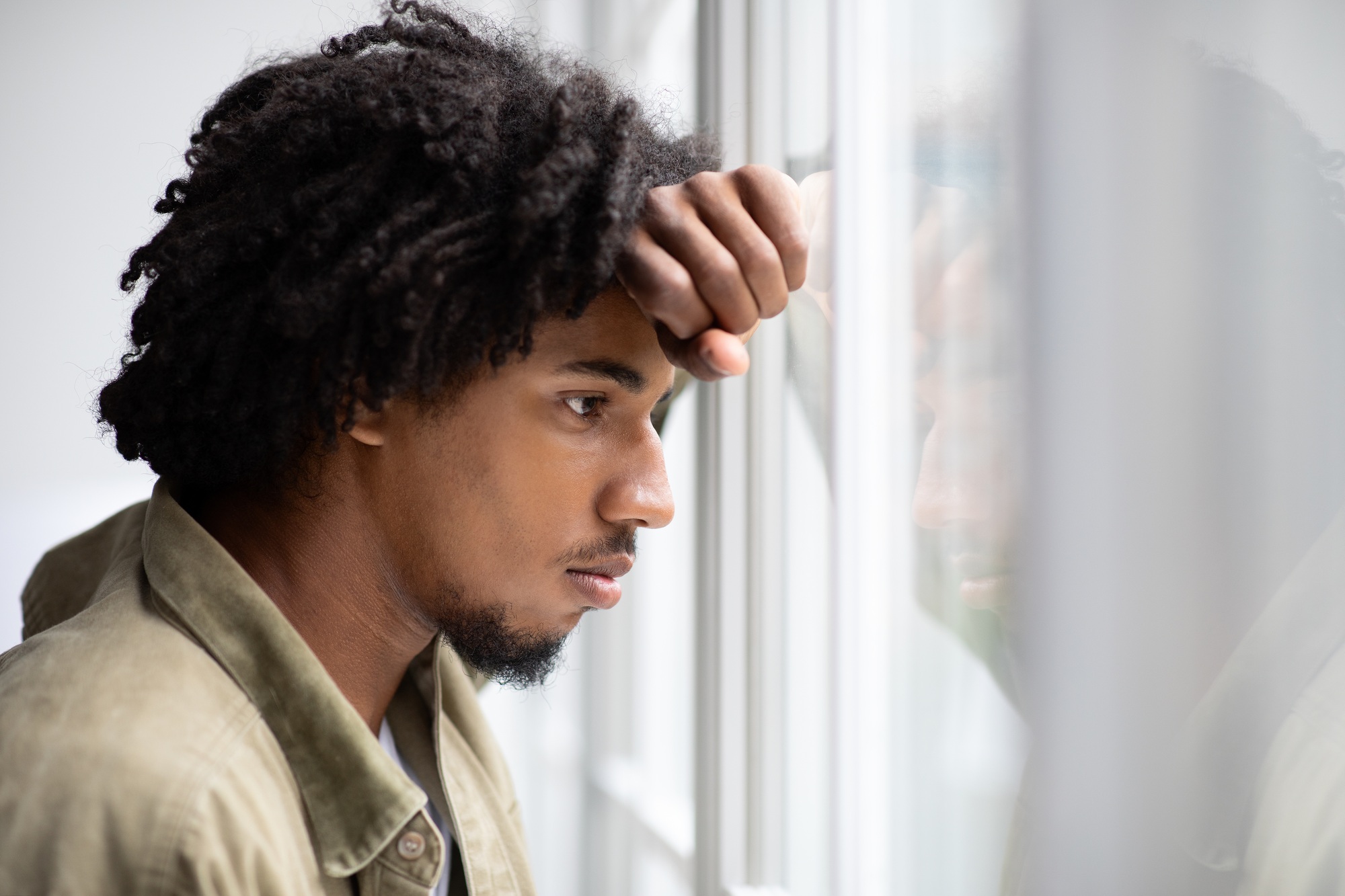 Depression Concept. Portrait Of Pensive Upset Young Black Man Looking Out Window