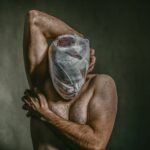topless man covered face with white bandage